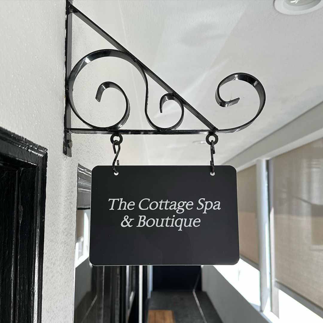 Hanging outdoor sign for The Cottage Spa & Boutique